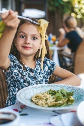 Creative Highlights Symbolfotos Ein kleines Mädchen stürzt sich glücklich auf eine Schüssel Nudeln mit grüner Pestosauce und Rucola, umgeben von der erfrischenden Atmosphäre eines Restaurants im Freien Ein kleines Mädchen stürzt sich glücklich auf eine Schüssel Nudeln mit grüner Pestosauce und Rucola, umgeben von der erfrischenden Atmosphäre eines Restaurants im Freien ,model released, Symbolfoto Copyright: xZoonar.com AnnaxLuryex 23079654 ,model released, Symbolfoto ,property released