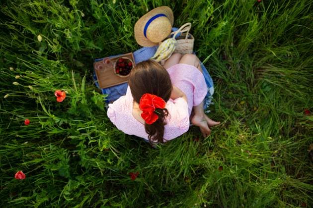 Eine junge Frau genießt ein ruhiges Picknick inmitten eines leuchtenden Mohnfeldes, umgeben von der Schönheit der Natur A young woman enjoys a tranquil picnic amidst a vibrant poppy field, surrounded by nature s beauty. ,model released, Symbolfoto Copyright: xZoonar.com SergiyxArtsabax 23126827 ,model released, Symbolfoto ,property released