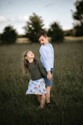 Creative Highlights Symbolfotos Siblings stand together and look back at each other. holding hands. Corby, England, United Kingdom CR_JNDO250327A-1691088-01 ,model released, Symbolfoto