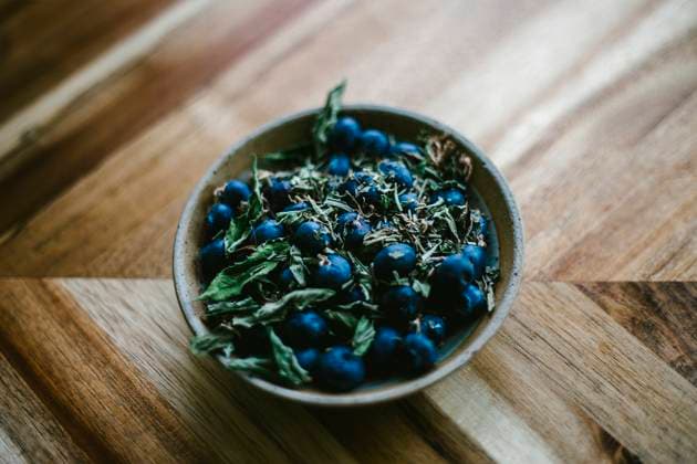Blueberry and Herbs in a Pottery Bowl Against a Wooden Background United States, Virginia, Front Royal R_NRUH250326A-1691632-01