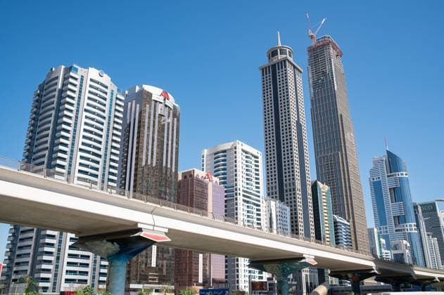 Creative Highlights World 16.03.2025, Dubai, Vereinigte Arabische Emirate, Asien - Blick auf die Skyline des Finanzzentrums mit seinen modernen Wolkenkratzern. Im Vordergrund fuehrt eine Hochtrasse der Dubai Metro die Sheikh Zayed Road entlang. *** 16 03 2025, Dubai, United Arab Emirates, Asia View of the skyline of the financial center with its modern skyscrapers In the foreground, an elevated line of the Dubai Metro runs along Sheikh Zayed Road