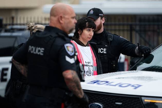 March 31, 2025, Ottawa, On, Canada: A protestor is detained by officers from the Ottawa Police Service (OPS) after the Tesla Service and Showroom centre was damaged with pink spray paint in Ottawa, on Monday, March 31, 2025. Ottawa Canada  - ZUMAc35_ 20250331_zaf_c35_009 Copyright: xSpencerxColbyx