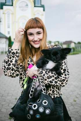 Creative Highlights Symbolfotos Smiling Redhead with Fluffy Dog and Chain Bag in Leopard Print Belarus, Brest Region, Kobryn R_ALLI250401E0-1207106-01 ,model released, Symbolfoto