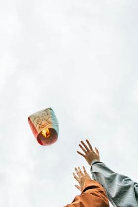 Creative Highlights Symbolfotos From below cropped unrecognizable people hands releasing a floating Chinese lantern, adorned with wishes and blessings for health, happiness, and prosperity, into the sky during a festival in Taiwan. Model Released JavierBallester_ID27513_789941_012 Copyright: xJavierxBallesterx