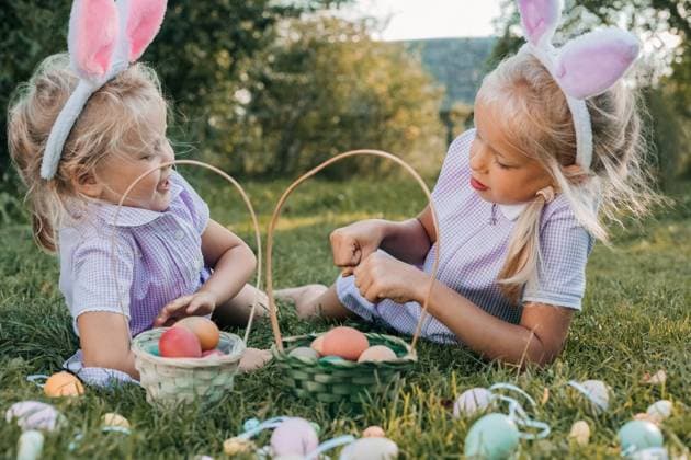 IMAGO Creative, Ostern, Bräuche, Eiersuche #2 Two cheerful children with bunny ears sit on grass, baskets full of colorful eggs, enjoying a playful Easter egg hunt in a sunny meadow surrounded by greenery. Model Released Nastyab_ID27533_790583_028 Copyright: xNastyabx RECORD DATE NOT STATED