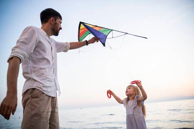 Creative Highlights Symbolfotos A father and daughter enjoy a fun time with a colorful kite on a beach in Italy. The girl excitedly holds the kite string while her father helps her launch it into the sky. Model Released NinaJaneckova_ID27433_788152_063 Copyright: xNinaxJaneckovax RECORD DATE NOT STATED