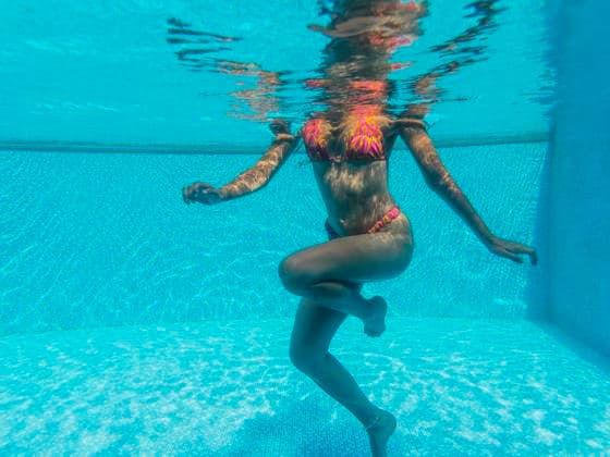 Creative Highlights Symbolfotos A woman in a colorful bikini is gracefully floating in a clear blue pool. Sunlight dances on the water s surface, creating a serene, tranquil atmosphere. Model Released PaulaBerezo_ID27669_794793_002 Copyright: xPaulaxBerezox RECORD DATE NOT STATED