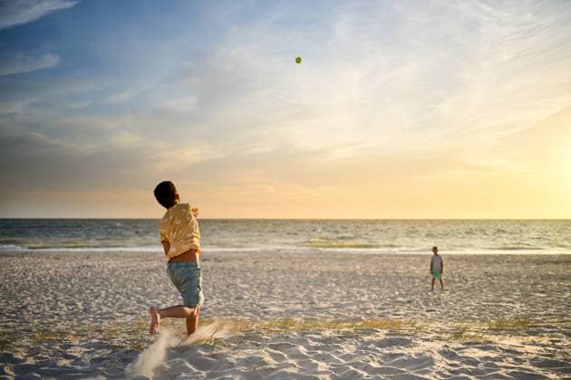 Boy throws ball to brother with beautiful sunset over the ocean Adelaide, South Australia, Australia CR_PAOL250404-1698017-01 ,model released, Symbolfoto