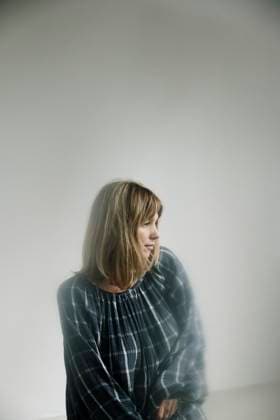 Creative Highlights Symbolfotos Woman in plaid dress barefoot near a bright window in a minimal room Amsterdam, North Holland, Netherlands CR_RTBZ250405FF-1700045-01 ,model released, Symbolfoto