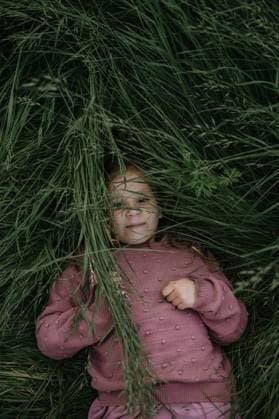 Creative Highlights Symbolfotos Girl lying in tall grass. she looking at the camera, top view. Corby, England, United Kingdom R_JNDO250402C-1694910-01 ,model released, Symbolfoto