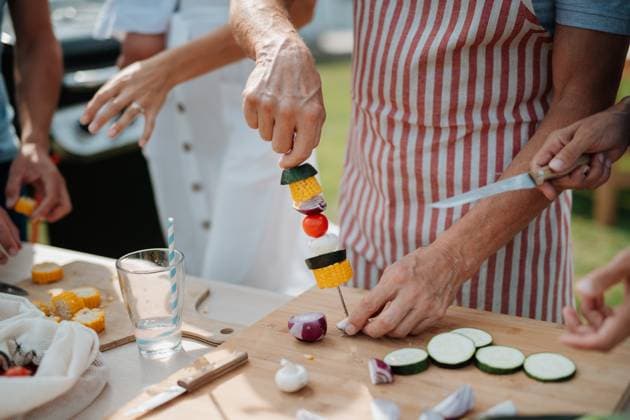 Close up of family preparing food for a spring weekend barbecue. Close up of family preparing food for a spring weekend barbecue. Garden party. model released
