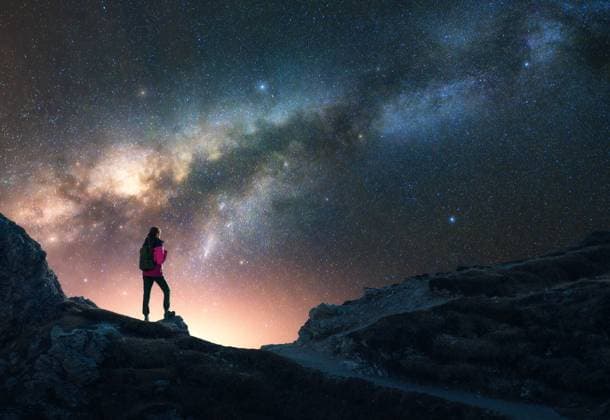 Glowing Milky Way and woman on mountain peak at starry night. Dolomites, Italy. Galaxy. Space landscape with silhouette of a girl, rocks, sky with bright stars. Milky Way and hiker. Nightscape Model Released DenisBilytskyi_ID27418_786784_013 Copyright: xx