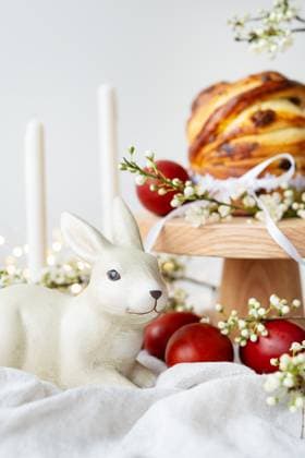 Festive table setting with ceramic bunny, red eggs, candles and Easter pastries. Easter holiday concept , 58299330.jpg, Easter, spring, decoration, festive, table, serving, ceramic, rabbit, red, eggs, candles, bread, wooden, stand, flowers, holiday, decor, bunny, figurine, white, fabric, gypsophila, ribbon, tied, bow, cozy, atmosphere, home, seasonal, theme, traditional, food, painted, centerpiece, floral, arrangement, warm, invitation, family, gathering, special, occasion, homemade, charming, fresh, design RECORD DATE NOT STATED