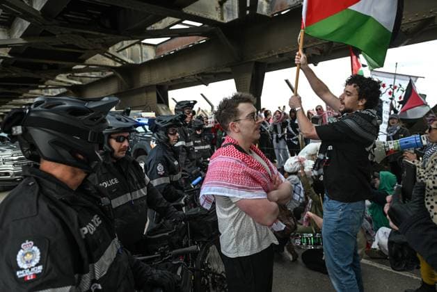 Demonstrators And Police Clash During Palestinian Solidarity Rally In Edmonton EDMONTON, CANADA APRIL 13 Members of the Edmonton Police attempt to push protesters off the vehicle lanes of the High Level Bridge and clear the way for traffic during the Stop the Genocide rally in Edmonton, Alberta, Canada, on April 13, 2025. The demonstration was held in solidarity with Palestinians amid growing demands for a ceasefire and international efforts to address the humanitarian crisis. Edmonton Canada  Copyright: xArturxWidakx originalFilename: widak-demonstr250413_npaPs.jpg