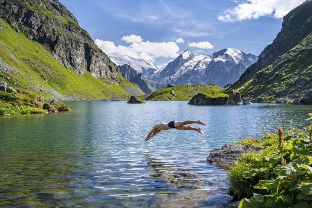 Mann macht Kopfsprung, Abkühlung beim Baden in Bergsee Lac de Louvie, hinten Gipfel der Grand Combin, Val de Bagnes, Wallis, Schweiz, Europa Man taking a header, cooling off while swimming in the mountain lake Lac de Louvie, behind the summit of the Grand Combin, Val de Bagnes, Valais, Switzerland, Europe Copyright: imageBROKER MoritzxWolf ibxmmw12956016.jpg ,model released, Symbolfoto ,property released