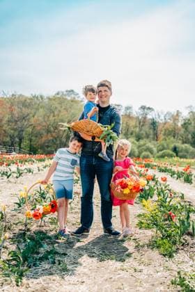 IMAGO Creative, Ostern, Bräuche, Osterspaziergang #2 Father and three kids standing in tulip field with baskets of flowers Ipswich, Massachusetts, United States CR_FKNH250409-1698979-01 ,model released, Symbolfoto