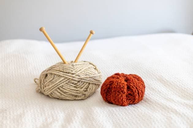 Off-white yarn and a burnt orange knit pumpkin Angier, North Carolina, United States R_KOUJ250409B-1649398-01
