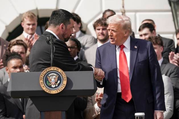 U.S. President Donald Trump shakes hands with Ryan Day, coach for the 2025 College Football National Champions - The Ohio State University when they were welcomed by Trump on the South Lawn of the White House in Washington, DC on Monday, April 14, 2025.  WAS20250414572 KenxCedeno