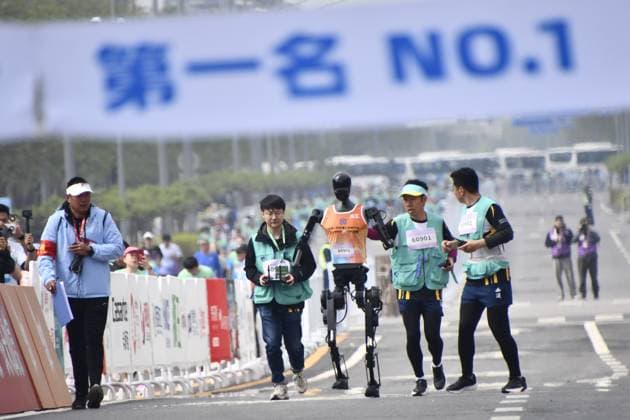 News Themen der Woche KW16 News Bilder des Tages China, Roboter nehmen am Peking E Town Halbmarathon teil (250419) -- BEIJING, April 19, 2025 -- Robotic participant Tiangong Ultra (C) competes as engineers run alongside during the Beijing E-Town half-marathon and humanoid robots half-marathon in the Beijing Economic-Technological Development Area in southeast Beijing, China, April 19, 2025. ) (SP)CHINA-BEIJING-E-TOWN HALF MARATHON AND HUMANOID ROBOTS HALF MARATHON (CN) LixXin 