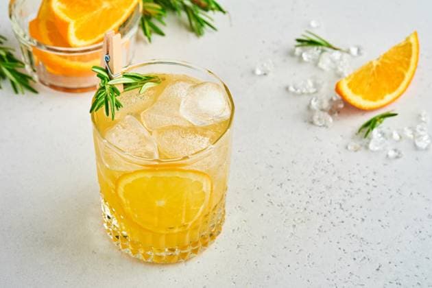Orangensaft oder Cocktail mit Rosmarin und Orange mit Eis im Glas, kalte Sommerlimonade auf hellgrauem Schiefer, Stein oder Beton Hintergrund. Strandkonzept mit tiefem Sonnenschatten. Ansicht von oben. Orange juice or cocktail with rosemary and orange with ice in glass, cold summer lemonade on light gray slate, stone or concrete background. Beach concept with deep sun shadow. Top view. (License=RF) Copyright: xZoonar.com KatsiarynaxHuravax 23210553