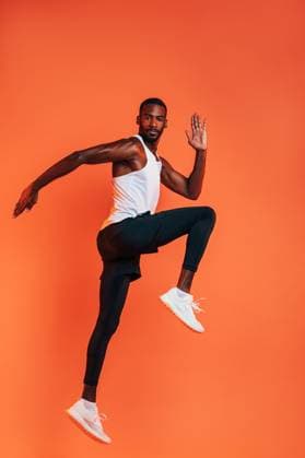 Creative Highlights Symbolfotos Sportler bei einem Stretching-Workout. Volle Länge des gesunden Fitness-Mannes, der vor einem orangefarbenen Hintergrund trainiert. Sportsman doing a stretching workout. Full length of healthy fitness man exercising against an orange background. (License=RF) ,model released, Symbolfoto Copyright: xZoonar.com ArtemxVarnitsinx 23221884 ,model released, Symbolfoto ,property released