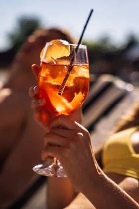 Closeup of young womans hand with neat red manicure holds elegant glass with long stem of aperol. Tasty citrus cocktail with orange slice. Sunny day, spa resort. , 59224822.jpg, drink, aperol, woman, glass, female, resort, luxury, spa, lifestyle, cocktail, summer, sun, swimsuit, travel, relaxation, relax, vacation, pool, outdoors, water, adult, young, holiday, blue, happy, girl, people, orange, person, summertime, leisure, sunlight, sexy, model, beach, happiness, poolside, attractive, outdoor, body, beauty, portrait, sea, swimming, sunglasses, bikini, resting, caucasian, enjoyment, beautiful RECORD DATE NOT STATED