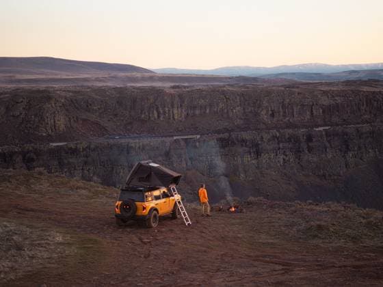 Overland truck and camper with campfire near canyon, Washington United States, Washington, Quincy CR_EVVA250419-1680250-01 ,model released, Symbolfoto
