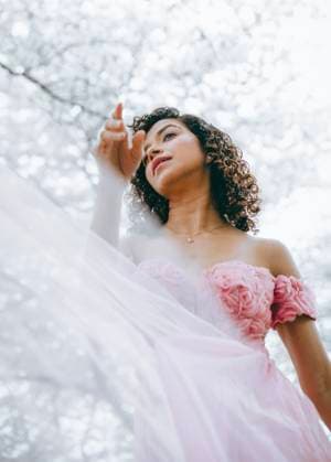 Creative Highlights Symbolfotos A woman with dark curls in a pink dress Philadelphia, Pennsylvania, United States CR_VDXM25042047-1708876-01 ,model released, Symbolfoto