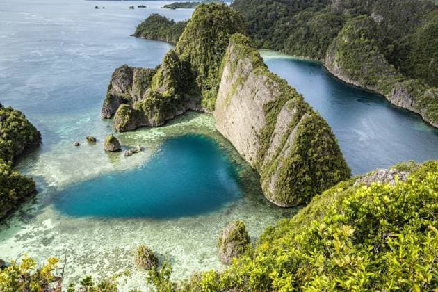 From above, a drone captures the breathtaking Raja Ampat Archipelago in Indonesia. The image shows vivid turquoise waters intertwining with lush, verdant cliffs and islands, highlighting the pristine beauty of this remote paradise. Model Released Gk-aut_ID27772_797271_002 Copyright: xGkxAutx RECORD DATE NOT STATED