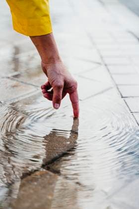 Creative Highlights Symbolfotos Woman s hand touching rain puddle on street model released, Symbolfoto, EBBF01245