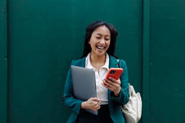 Creative Highlights Symbolfotos Businesswoman smiling while using smartphone outdoors model released, Symbolfoto, ASGF06292