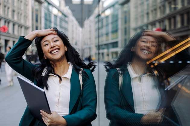 Creative Highlights Symbolfotos Smiling businesswoman standing on a city street with her reflection in glass model released, Symbolfoto, ASGF06296