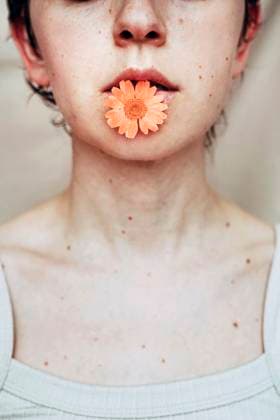 Creative Highlights Symbolfotos Artistic portrait of a woman with an orange flower in her lips model released, Symbolfoto, SVCF00453