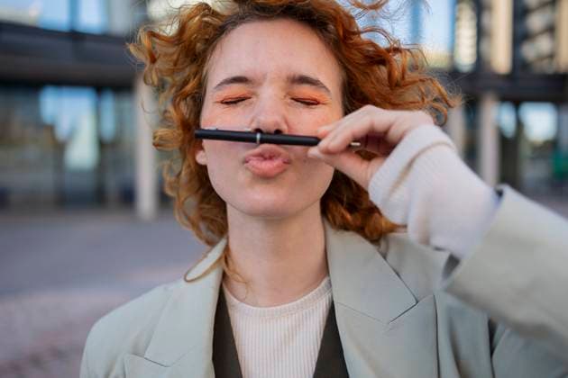 Creative Highlights Symbolfotos Playful businesswoman with curly hair holding pen as mustache outdoors model released, Symbolfoto, ALZF01262
