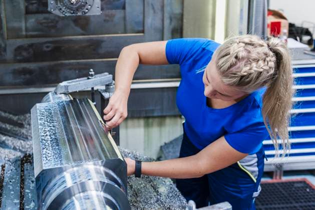 Young woman working on machinery in an industrial production hall model released, Symbolfoto property released, DIGF24190