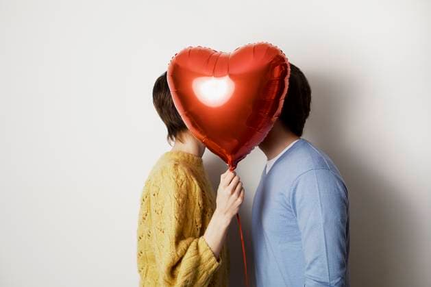 Couple hiding behind a heart-shaped balloon indoors model released, Symbolfoto property released, PWF01353