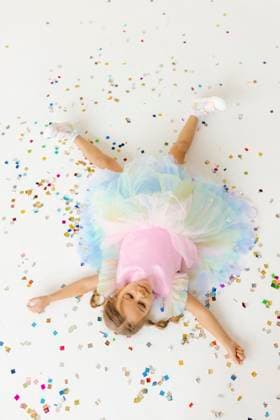 Creative Highlights Symbolfotos Girl in a colorful tutu lying on the floor surrounded by confetti, celebrating with joy and excitement model released, Symbolfoto property released, VIVF01637