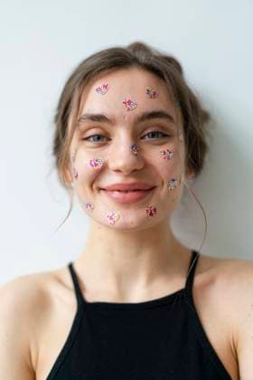 Creative Highlights Symbolfotos Smiling woman with decorative stickers on her face in a loft apartment model released, Symbolfoto property released, KNSF11313