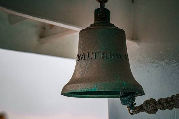 Schiffsglocke der BALTRUM II maritimes Detail Neßmersiel, Deutschland, Europa, Detailaufnahme der Patina-bedeckten Schiffsglocke mit der Gravur BALTRUM II an Bord des gleichnamigen Frachtschiffs der Baltrum-Linie. Die Glocke ist traditioneller Bestandteil der Sicherheits- und Signalausstattung und steht symbolisch für maritime Tradition und Schifffahrtskultur im ostfriesischen Raum. *** Ships bell of the BALTRUM II maritime detail Neßmersiel, Germany, Europe, Close-up of the patina-covered ships bell with the engraving BALTRUM II on board the cargo ship of the same name of the Baltrum Line The bell is a traditional part of the safety and signaling equipment and is symbolic of maritime tradition and shipping culture in the Copyright: xJOERANxSTEINSIEKx
