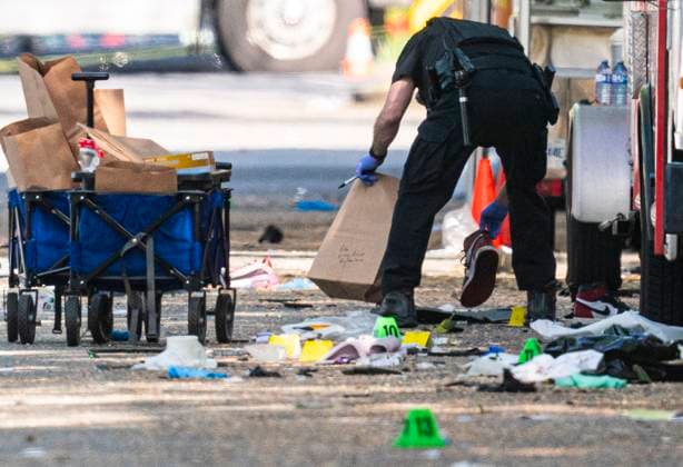 April 27, 2025, Vancouver, Bc, CANADA: A member of the Vancouver Police forensics team picks up a shoe while investigating the scene where a vehicle drove into crowd at a street festival Saturday evening in Vancouver, Sunday, April 27, 2025. Vancouver CANADA  - ZUMAc35_ 20250427_zaf_c35_075 Copyright: xRichxLamx