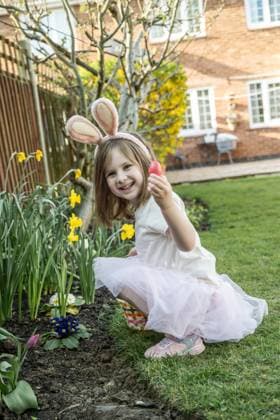 IMAGO Creative, Ostern, Bräuche, Eiersuche #2 Toddler girl in bunny ears in the garden searching chocolate eggs Corby, England, United Kingdom CR_ATMT250427D-1708431-01 ,model released, Symbolfoto