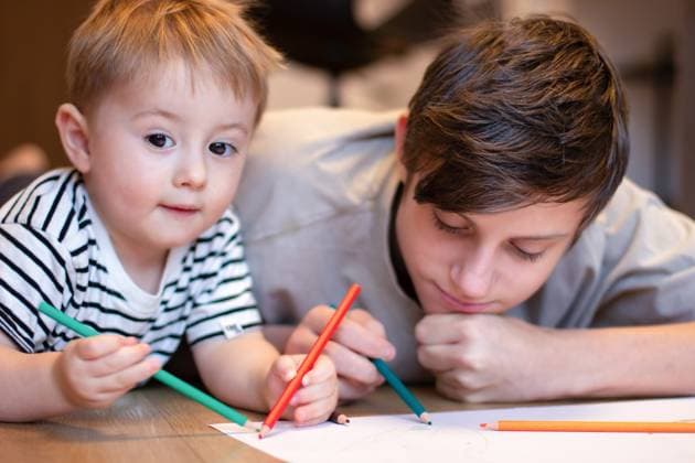 Zwei Kinder zeichnen mit Buntstiften. Ein Teenager und ein jüngerer Bruder zeichnen im Liegen Two children draw with colored pencils. A teenager and a younger brother draw while lying on the floor. High quality photo (License=RF) ,model released, Symbolfoto Copyright: xZoonar.com LiudmylaxLazoryshynax 23287450 ,model released, Symbolfoto ,property released