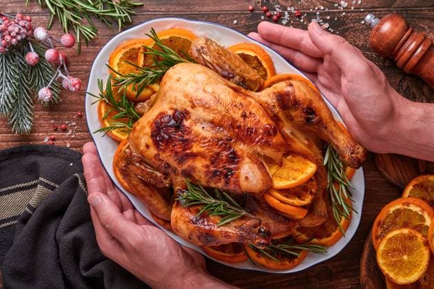 Gebratenes oder gebackenes ganzes Huhn mit Rosmarin und Orangen, hausgemacht für das traditionelle Weihnachts-Familienessen auf einem alten rustikalen Holztisch. Draufsicht mit Kopierbereich. Roasted or baked whole chicken with rosemary and oranges, homemade for Christmas traditional family dinner on an old wooden rustic table. Top view with copy space. (License=RF) Copyright: xZoonar.com KatsiarynaxHuravax 23276289