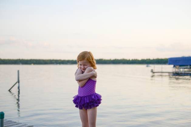 Creative Highlights Symbolfotos Creative Highlights Symbolfotos Little redhead girl in purple swimsuit hugging herself by a lake. Merrifield, MN, United States R_RDOL210428A-729555-01 ,model released, Symbolfoto