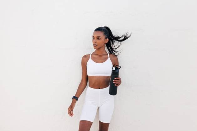 Creative Highlights Symbolfotos Porträt einer schlanken Sportlerin mit einem Shaker vor einer weißen Wand. Frau in weißer Fitnesskleidung hält eine Flasche. Portrait of a slim sportswoman with a shaker at a white wall. Female in white fitness attire holding a bottle. (License=RF) ,model released, Symbolfoto Copyright: xZoonar.com ArtemxVarnitsinx 23302970 ,model released, Symbolfoto ,property released