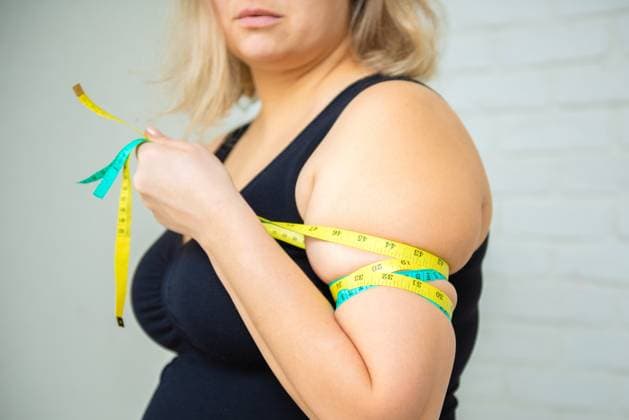 Eine dicke Frau ist übergewichtig. Sie misst ihren Armumfang mit einem Maßband. Sie möchte abnehmen. Konzept der Gewichtsabnahme A fat woman is overweight. She measures her arm circumference with a tape measure. She wants to lose weight. Weight loss concept (License=RF) ,model released, Symbolfoto Copyright: xZoonar.com IrinaxPavlovax 23331285 ,model released, Symbolfoto ,property released