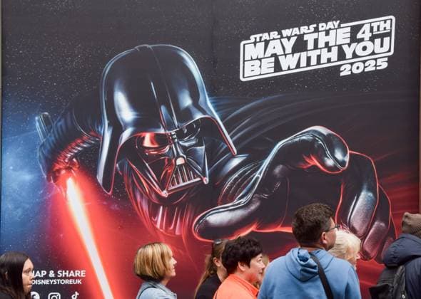 May 4, 2025, London, England, United Kingdom: Customers queue outside the Disney store on Oxford Street next to artwork featuring Darth Vader and the phrase May the fourth be with you on Star Wars Day. London United Kingdom - ZUMAv130 20250504_zip_v130_001 Copyright: xVukxValcicx