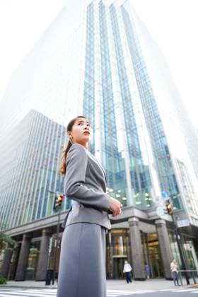 Creative Highlight Symbolbilder Frau im grauen Anzug steht vor einem hohen Gebäude Woman in a gray suit is standing in front of a tall building. She is looking up at the sky (License=RF) ,model released, Symbolfoto Copyright: xZoonar.com EkaterinaxPereslavtsevax 23370638 ,model released, Symbolfoto ,property released