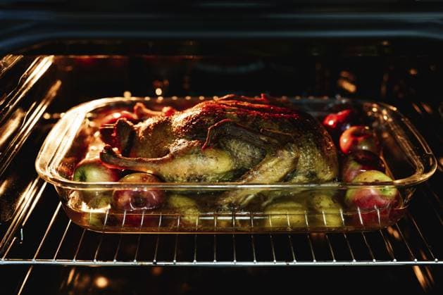 Weihnachtsessen Ente mit Äpfeln und Kartoffeln wird im Ofen gebacken Christmas dinner - duck with apples and potatoes is baked in the oven. Copyright: imageBROKER NadtochiyxVladimir ibxiqx13175182.jpg