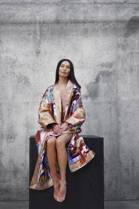 Frau in farbenfrohem traditionellen asiatischen Patchwork Gewand, die auf einem großen Würfel sitzt Woman wearing colorful traditional Asian patchwork robe and sitting on a large cube Copyright: imageBROKER ArmanxZhenikeyev ibxazh13361133.jpg ,model released, Symbolfoto ,property released